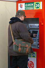 Rewal  Polen  ein Mann hebt Geld vom Geldautomaten ab