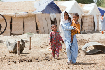 Lujja Khan Jakrani  Pakistan  Maedchen stehen vor behelfmaessigen Huetten