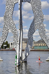 Berlin  Deutschland  Stehpaddler unter der Skulptur Molecule Men