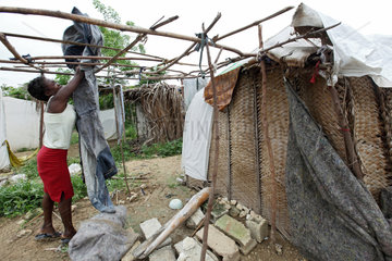 Leogane  Haiti  eine Frau spannt eine Decke als Dach ueber ihre Notunterkunft