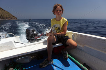 Alicudi  Italien  Junge lenkt ein Motorboot auf dem Meer