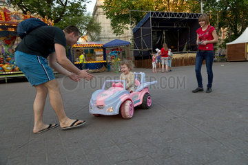 Lemberg  Ukraine  Familie mit Tochter in einem von der Mutter ferngesteurten Spielzeugauto