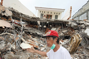 Padang  Indonesien  ein Mann vor einem zerstoerten Gebaeude