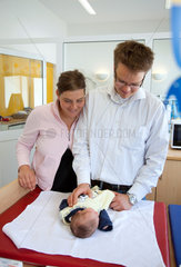 Essen  Deutschland  Mutter und Vater wickeln ihr neugeborenes Baby im Wickelzimmer