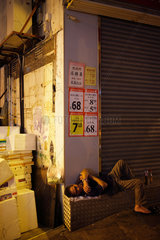 Hongkong  China  Obdachloser schlaeft vor einem geschlossenen Geschaeft