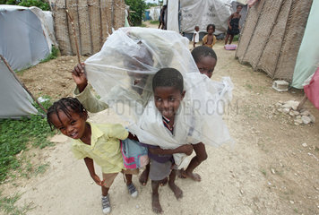 Leogane  Haiti  Kinder spielen mit einer Plastikplane in einem Fluechtlingslager
