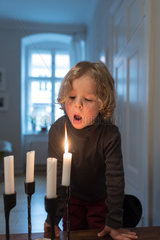 Berlin  Deutschland  kleines Maedchen pustet Kerzen aus