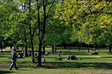 Berlin  Deutschland  Menschen sitzen auf der Wiese im Volkspark Friedrichshain