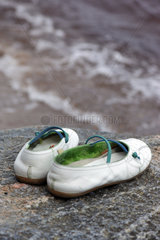 Staberdorf  Fehmarn  Schuhe wurden auf einem Stein am Strand bei Staberhuk abgestellt