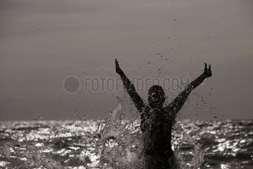 Kaegsdorf  Deutschland  Silhouette  Frau springt aus dem Meer heraus