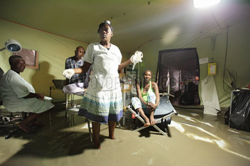 Carrefour  Haiti  Krankenschwester mit Infusionsflasche in der Hand steht im Wasser