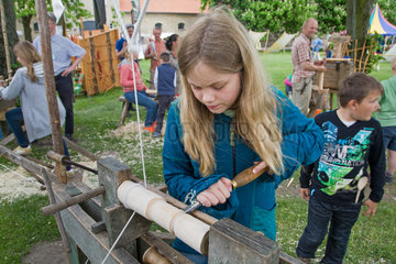 Schleswig  Deutschland  Maedchen probiert eine historische Drechselmaschine aus