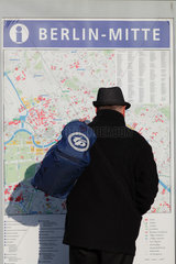 Berlin  Deutschland  Mann betrachtet einen Stadtplan auf dem Alexanderplatz