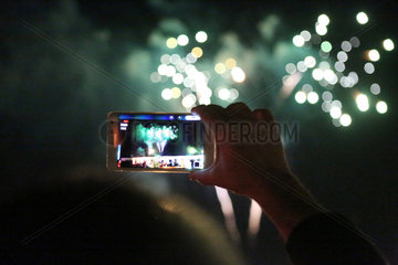 Dubai  Vereinigte Arabische Emirate  Feuerwerk wird mit einem Smartphone fotografiert