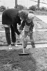 Berlin  DDR  Vorschulkind und Lehrerin bei der Gartenarbeit im Schulgarten
