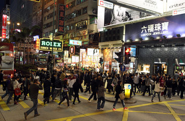 Hong Kong  China  Menschen ueberqueren bei Nacht eine Strasse im Stadtteil Kowloon