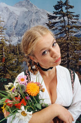 Hamburg  Deutschland  Frau im Dirndl mit einem Blumenstrauss
