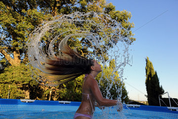 Torre Alfina  Italien  Maedchen wirft im Swimmingpool ihr nasses Haar zurueck