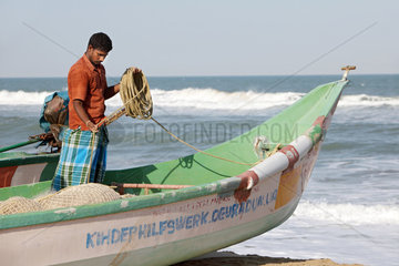Alikuppam  Indien  ein Fischer in seinem Boot am Strand