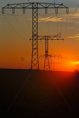 Klein-Mutz  Deutschland  Hochspannungsmasten einer Stromtrasse bei Sonnenuntergang