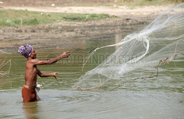 Karumanchi  Indien  ein Fischer wirft sein Netz aus