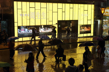 Hong Kong  China  Menschen bei Nacht im Regen vor einem Juweliergeschaeft der CSS