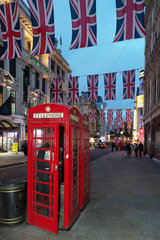 London  Grossbritannien  klassische rote Telefonzelle und Union Flags am Abend