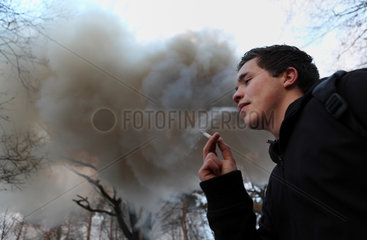Wandlitz  Deutschland  Rauchender Mann vor einer grossen Qualmwolke