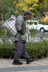 Tokio  Japan  Symbolfoto Armut  ein Mann laeuft eine Strasse entlang