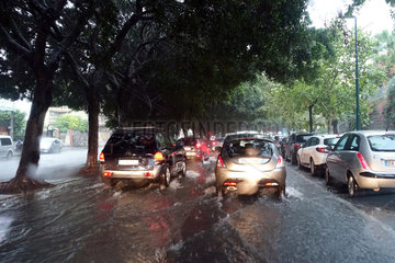 Aci Trezza  Italien  Autos fahren auf einer von Regenwasser ueberfluteten Strasse
