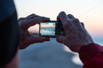 Kussfeld  Polen  Tourist fotografiert am Strand nach Sonnenuntergang