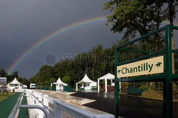Chantilly  Frankreich  Regenbogen ueber dem Fuehrring der Galopprennbahn