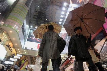 Hong Kong  China  Menschen bei Regen im Stadtteil Causeway Bay bei Nacht