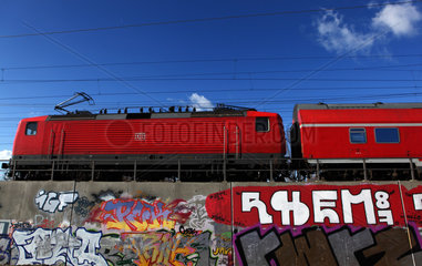 Berlin  Deutschland  Regionalbahn faehrt ueber eine mit Graffiti bespruehte Bahntrasse