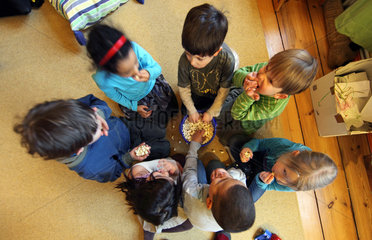 Berlin  Deutschland  Kinder essen Popcorn aus einem Eimer