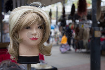 Berlin  Deutschland  Puppe mit Peruecke auf einem Wochenmarkt in Steglitz