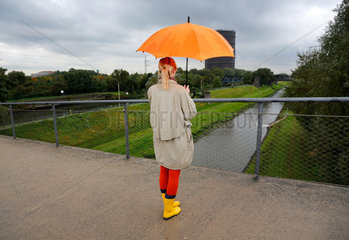 Oberhausen  Deutschland  eine junge Frau geht bei Regenwetter mit Regenschirm spazieren