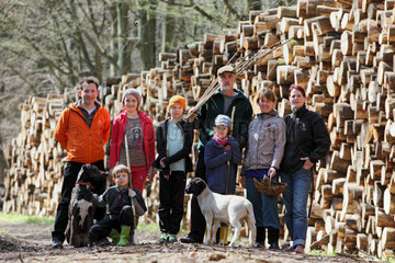 Neu Kaetwin  Deutschland  befreundete Familien stehen vor einem Holzstoss im Wald