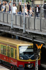Berlin  Deutschland  Passanten auf der Warschauer Bruecke  darunter eine S-Bahn