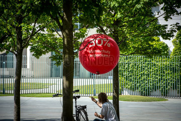 Berlin  Deutschland  eine Frau befestigt einen Ballon an einem Fahrrad