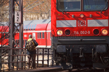 Berlin  Deutschland  ein Mann vom Sicherheitsdienst an den Gleisen und ein fahrender Regionalzug