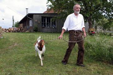 Neu Kaetwin  Deutschland  Mann geht mit seinem Ziegenbock spazieren