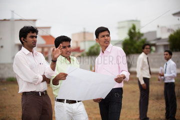 Coimbatore  Indien  junge indische Geschaeftsmaenner mit Bauplan