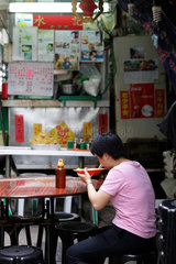 Hongkong  China  eine Frau sitzt alleine in einer Garkueche in Hongkong Central