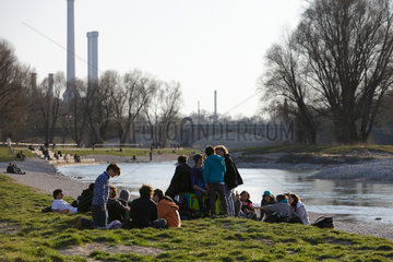 Muenchen  Deutschland  Jugendliche sitzen am Ufer der Isar