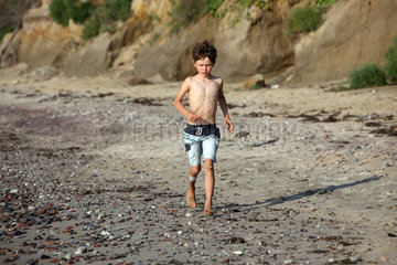 Kaegsdorf  Deutschland  Junge laeuft am Strand entlang