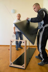 Posen  Polen  zwei Maenner bauen einen Ikea-Schrank auf