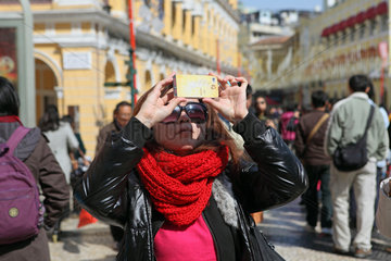 Macau  China  Frau macht ein Foto mit ihrem Mobiltelefon
