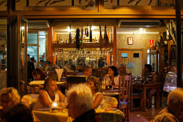 Port d'Alcudia  Mallorca  Spanien  Gaeste sitzen abends in einer Bar