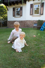 Saarbruecken  Deutschland  ein grosser Bruder mit seiner kleinen Schwester im Garten